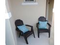 Close up view of two chairs with patterned throw pillows on a cozy front porch at 5123 Crown Haven Dr, Kissimmee, FL 34746