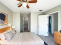 Inviting bedroom features ceiling fan, neutral paint, and ensuite bathroom, creating a comfortable and private retreat at 5126 Picadilly Circus Ct # 11, Orlando, FL 32839