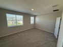Bright bedroom with large windows, neutral carpet, and a closet at 628 Pothos St, Apopka, FL 32703