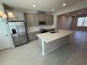 Modern kitchen with stainless steel appliances, gray cabinets, granite countertops, and tile flooring at 628 Pothos St, Apopka, FL 32703