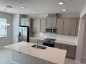 Modern kitchen features stainless steel appliances, granite countertops, and gray cabinets at 628 Pothos St, Apopka, FL 32703