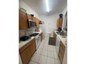 Efficient kitchen with tile floor, wooden cabinets, and white appliances at 6434 Cava Alta Dr # 303, Orlando, FL 32835