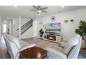 Cozy living room featuring modern furnishings, a decorative fireplace, and stairway access at 7649 Ragusa Way, Clermont, FL 34714