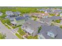 An elevated view of a two-story home with manicured landscaping and mature trees in a serene neighborhood setting at 7831 Dausset St, Orlando, FL 32827