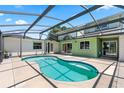 Backyard with a kidney-shaped pool features a screened in patio with a view of the home's windows and doors at 905 Ocala Woods Ln, Orlando, FL 32824