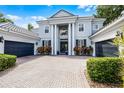 Elegant two-story home with multiple garage bays, a paver driveway, and landscaped front yard at 11014 Hawkshead Ct, Windermere, FL 34786