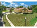Expansive lawn and mature trees surround this charming two-story home on a large corner lot at 12222 Cypress Landing Ave, Clermont, FL 34711