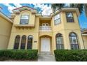 Stately two-story home featuring a private balcony, arched windows, and elegant double doors at 12222 Cypress Landing Ave, Clermont, FL 34711