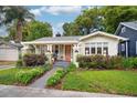 Inviting home exterior with vibrant flowerbeds, sidewalk, and colorful front door at 14 N Lawsona Blvd, Orlando, FL 32801