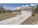Exterior view of the home's attached one car garage and concrete driveway at 1602 Sheffield Rd, Leesburg, FL 34748