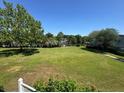 Expansive green backyard featuring mature trees and lush landscaping under a clear blue sky at 1695 Lee Rd # E214, Winter Park, FL 32789