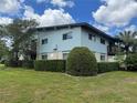Two story light blue building with well-maintained lawn and mature landscaping at 1695 Lee Rd # E214, Winter Park, FL 32789
