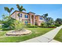 Beautifully landscaped home with palm trees, lush lawn, and a charming stone accent wall at 17117 Cypress Preserve Pkwy, Orlando, FL 32820