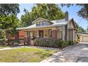 Charming home with a brick chimney, well manicured lawn and mature landscaping at 210 E Kaley St, Orlando, FL 32806