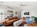 Cozy living room with modern ceiling fan, comfortable leather sofa, and bright natural light at 210 E Kaley St, Orlando, FL 32806