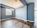 Formal dining room with a modern chandelier, wood floors, and neutral wall color at 2145 Plantation Oak Dr, Orlando, FL 32824