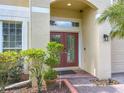 Close-up of front door with glass panes, showing brick walkway and manicured landscaping at 2145 Plantation Oak Dr, Orlando, FL 32824