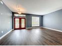 Spacious living room with gray walls, dark wood floors, and a double door entryway at 2145 Plantation Oak Dr, Orlando, FL 32824