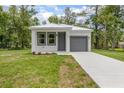 Charming single-Gathering home with a well-maintained lawn and a gray front door and garage at 2259 3Rd Ave, Deland, FL 32724