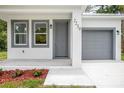Inviting front entrance with a well-manicured yard and gray front door and garage at 2259 3Rd Ave, Deland, FL 32724