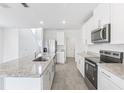 Bright kitchen features stainless appliances, granite countertops, white cabinets, and tile flooring at 2774 Virginia Pine Dr, Bartow, FL 33830