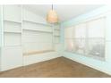 Bright living area with custom built-ins, wood floors and an accent light fixture at 304 Little Springs Ln, Longwood, FL 32750