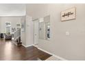 Bright and inviting foyer featuring hardwood floors, staircase, and stylish decor at 386 Riggs Cir, Davenport, FL 33897