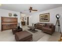 Well-lit living room featuring a ceiling fan, neutral paint, and comfortable brown furniture at 4495 Bedford Rd, Sanford, FL 32773