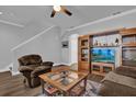 Cozy living room with hardwood floors, ceiling fan, and entertainment center creating a warm atmosphere at 6218 Forsythe Loop, Sanford, FL 32771