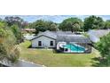 Aerial view of the backyard screened-in pool, with a patio area and an umbrella covered table at 731 Rosemere Cir, Orlando, FL 32835