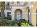 Charming home entrance with an arched doorway, enhanced by lush landscaping, and a tranquil setting at 10339 Kensington Shore Dr # J-202, Orlando, FL 32827