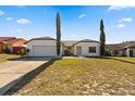 Well-maintained single-story house featuring a two-car garage and green lawn at 1135 Marni Ridge Ct, Kissimmee, FL 34747