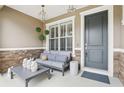 Inviting front porch with stone accents, comfortable seating, and stylish decor at 11725 Verrazano Dr, Orlando, FL 32836