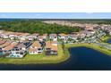 Aerial view of a lakeside community with homes featuring tile roofs and access to a tranquil lake at 13090 Bromborough Dr, Orlando, FL 32832