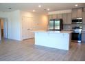 Bright modern kitchen with stainless steel appliances, island and tile flooring perfect for cooking and entertaining at 141 Addle Hill Ct, Deland, FL 32720