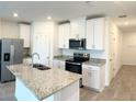 Modern kitchen with white cabinets, stainless steel appliances, and granite countertops at 16284 Hamlin View St, Winter Garden, FL 34787