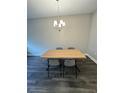 Minimalist dining area showcasing a modern table and chair set illuminated by an elegant chandelier at 16290 Hamlin View St, Winter Garden, FL 34787