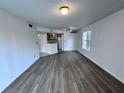 Open-concept living room leading to kitchen area, featuring sleek laminate flooring and natural light at 1908 Lake Atriums Cir # 20, Orlando, FL 32839
