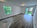 Spacious living room with a large window, sliding glass doors, and laminate flooring at 1908 Lake Atriums Cir # 20, Orlando, FL 32839