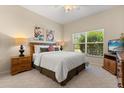 Cozy bedroom featuring a comfortable bed, soft lighting, and a window with blinds for natural light at 24104 Peekskill St, Leesburg, FL 34748
