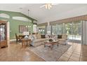 Spacious living room with large windows overlooking the pool and outdoor area, perfect for relaxation at 24104 Peekskill St, Leesburg, FL 34748