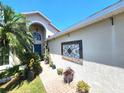 Beautiful home entrance with arched doorway, landscaped walkway, and decorative details at 2426 Hybrid Dr, Kissimmee, FL 34758
