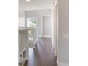 Upstairs hallway featuring wood floors, white banisters and trim, with a view of natural light from a nearby window at 3004 Cottage Grove Ct # 1805, Orlando, FL 32822