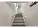 Clean, carpeted staircase featuring white railings, leading to the upper level, reflecting a bright and airy ambiance at 3004 Cottage Grove Ct # 1805, Orlando, FL 32822