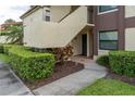 Charming condo entrance featuring a private walkway, manicured hedges, and neutral stucco facade at 3221 Westridge Blvd # 103, Orlando, FL 32822