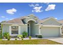 Inviting single-story home boasts a well-manicured lawn, a two-car garage, and attractive architectural detailing at 4153 Cortland Dr, Davenport, FL 33837