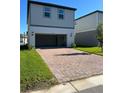 Spacious brick driveway leading to a two-car garage with a well-manicured lawn at 4716 Homestead Trl, St Cloud, FL 34772