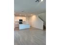 Open-concept kitchen features white cabinets, an island, and sleek tile flooring at 4720 Homestead Trl, St Cloud, FL 34772