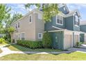 Two-story townhome showing manicured shrubs and healthy green lawn on a bright, sunny day at 5037 Hawkstone Dr, Sanford, FL 32771