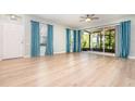Bright, open living room with laminate flooring, ceiling fan, large sliding doors leading to screened patio at 5037 Hawkstone Dr, Sanford, FL 32771